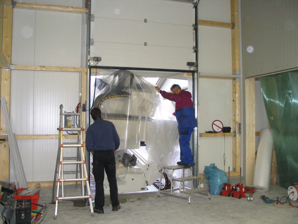Bauarbeiter bei der Montage eines großen Tores in einer Halle der Ebert Kunststoffbearbeitung.