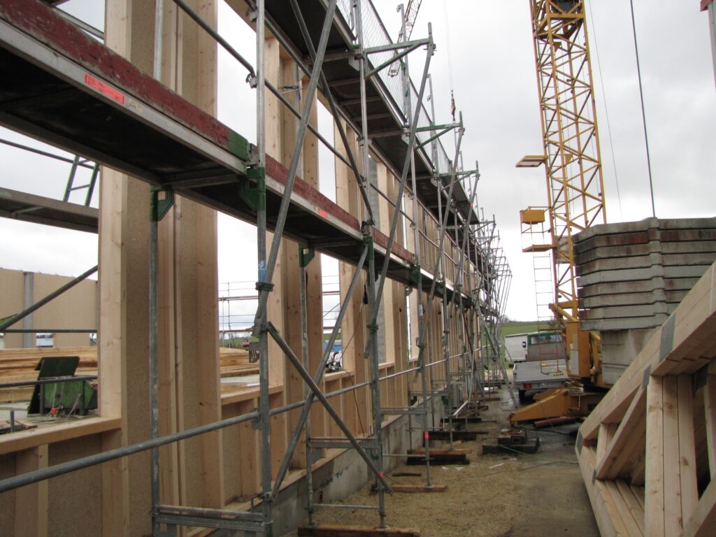 Bauprojekt Halle 3 der Ebert Kunststoffbearbeitung im Rohbau mit Geruesten und Kran.
