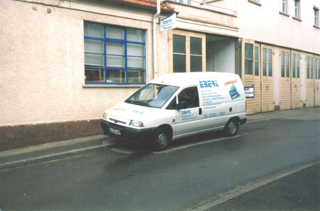 Lieferwagen der Ebert Kunststoffbearbeitung vor einem Firmengebaeude in den Anfangsjahren.