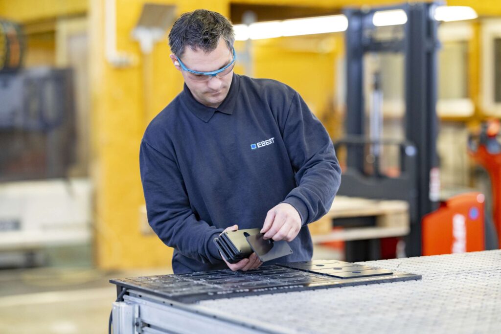 Ein Mitarbeiter bearbeitet technische Kunststoffe in einem modernen Produktionsumfeld.