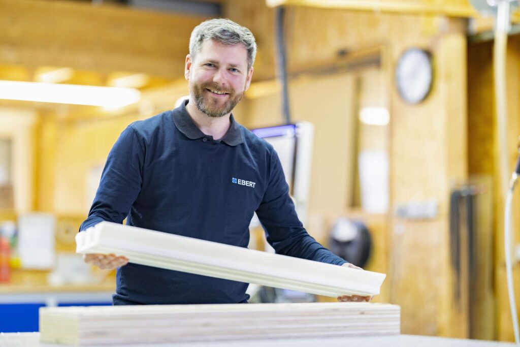 Mitarbeiter von Ebert Kunststoffbearbeitung in einer Werkstatt beschaeftigt an Kunststoffteilen.