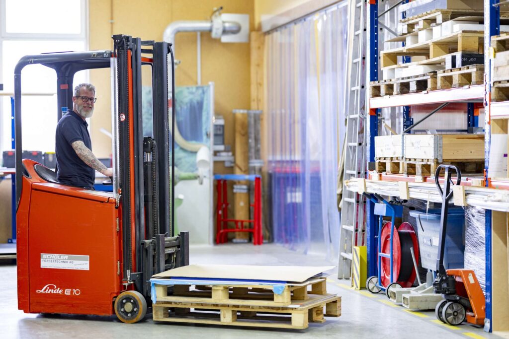 Lagerarbeiter bewegt Paletten mit einem Gabelstapler in der Ebert Kunststoffbearbeitung Firma.