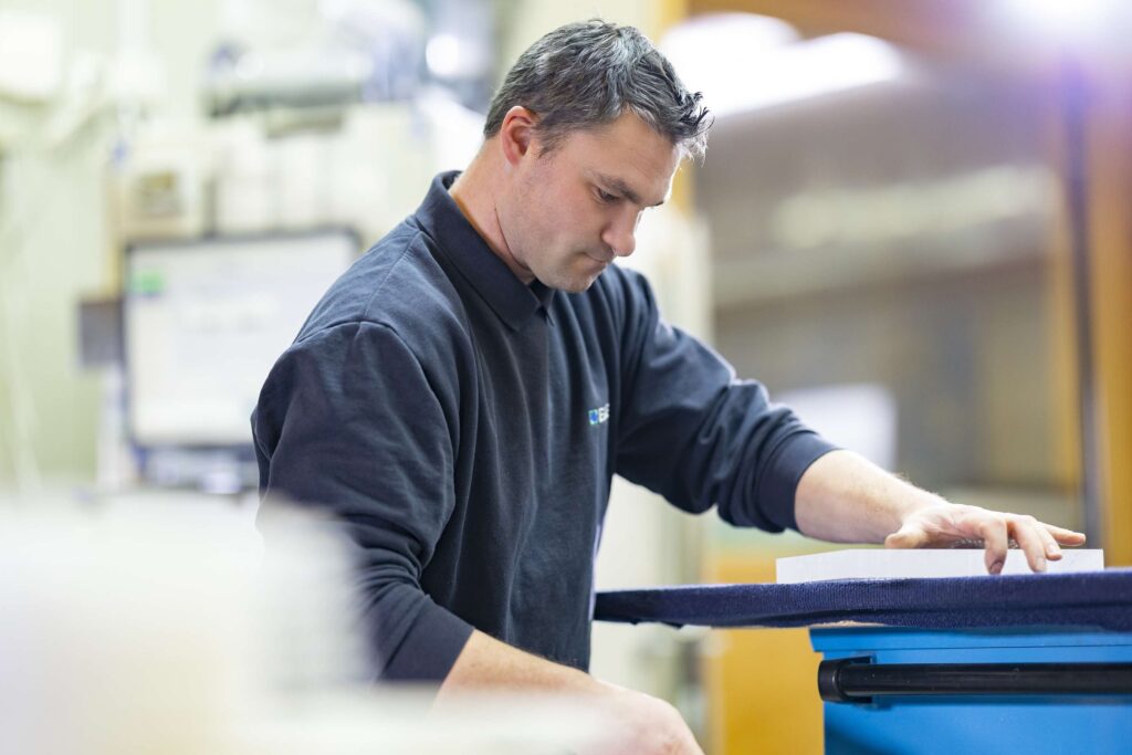 Mitarbeiter von Ebert Kunststoffbearbeitung bei der Arbeit an einer Maschine in der Werkstatt.