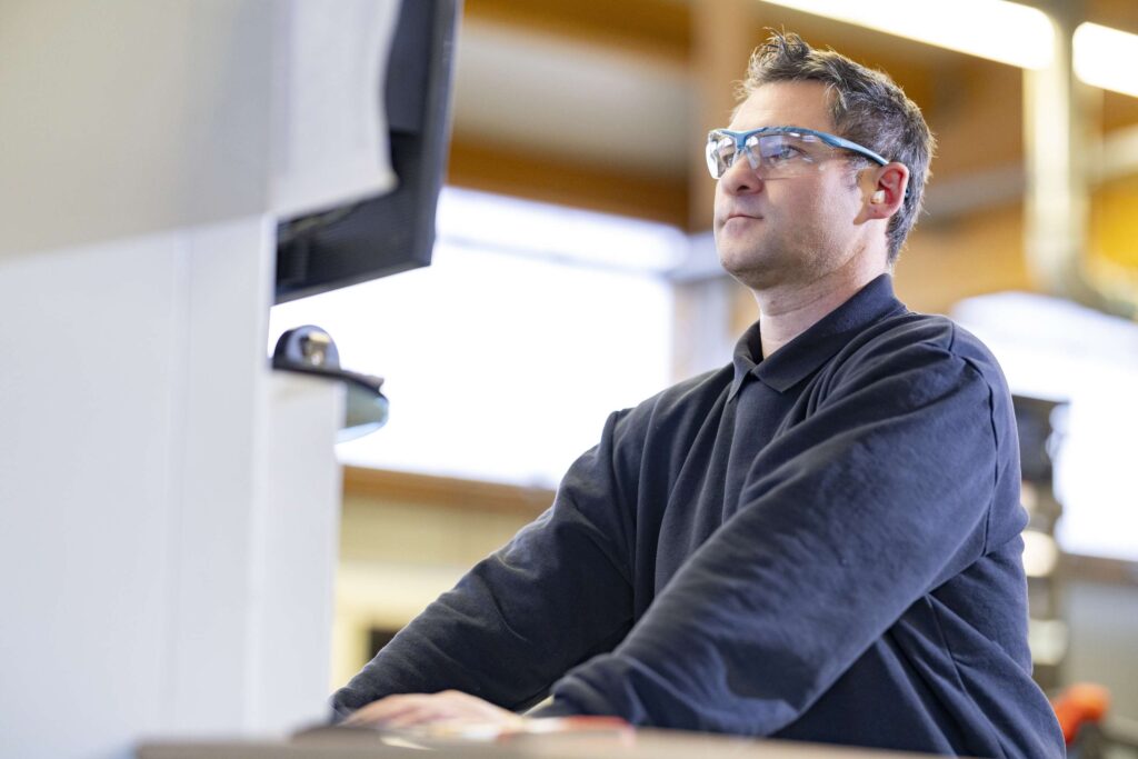 Mitarbeiter der Ebert Kunststoffbearbeitung in der Produktion mit Schutzbrille.