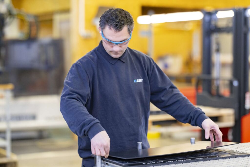 Ein Mitarbeiter von Ebert Kunststoffbearbeitung arbeitet praezise an technischen Kunststoffen in der Werkstatt.