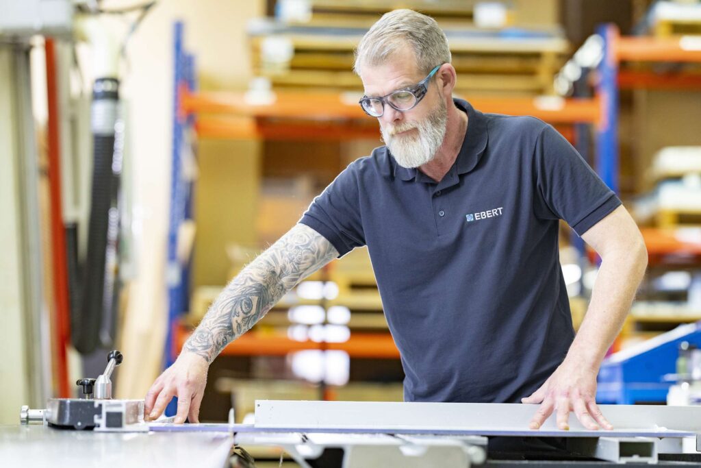 Ein Mitarbeiter von Ebert Kunststoffbearbeitung arbeitet an einer Maschine.