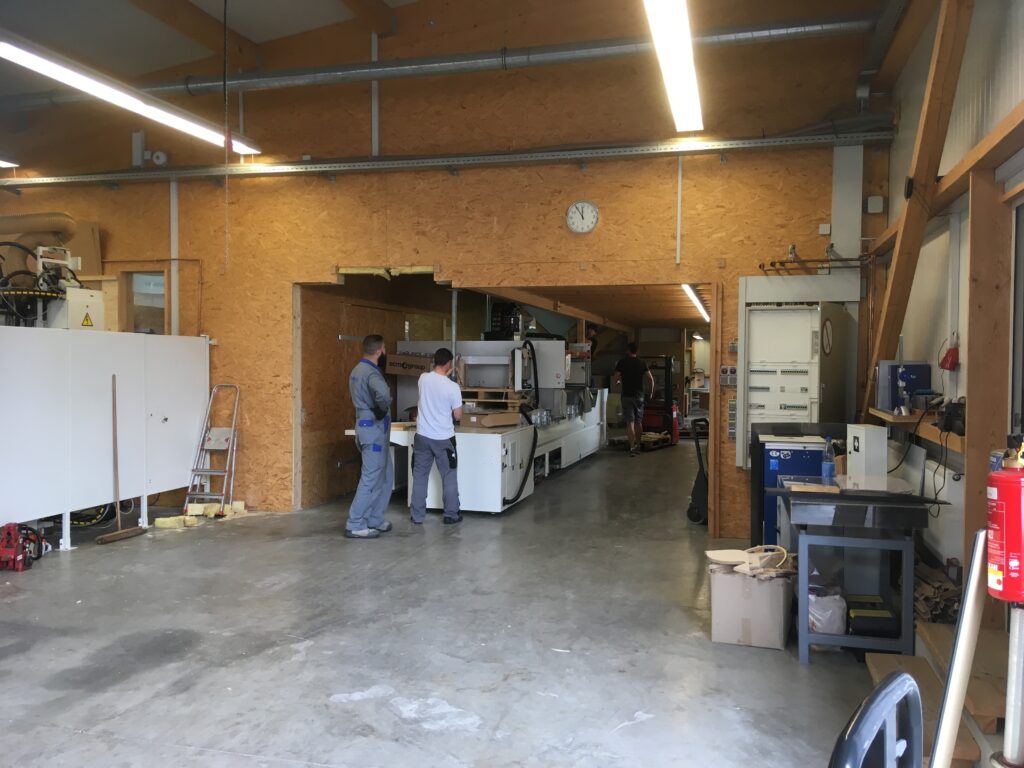 Innenansicht der Werkhalle von Ebert Kunststoffbearbeitung mit neuen Maschinen und Mitarbeitern.