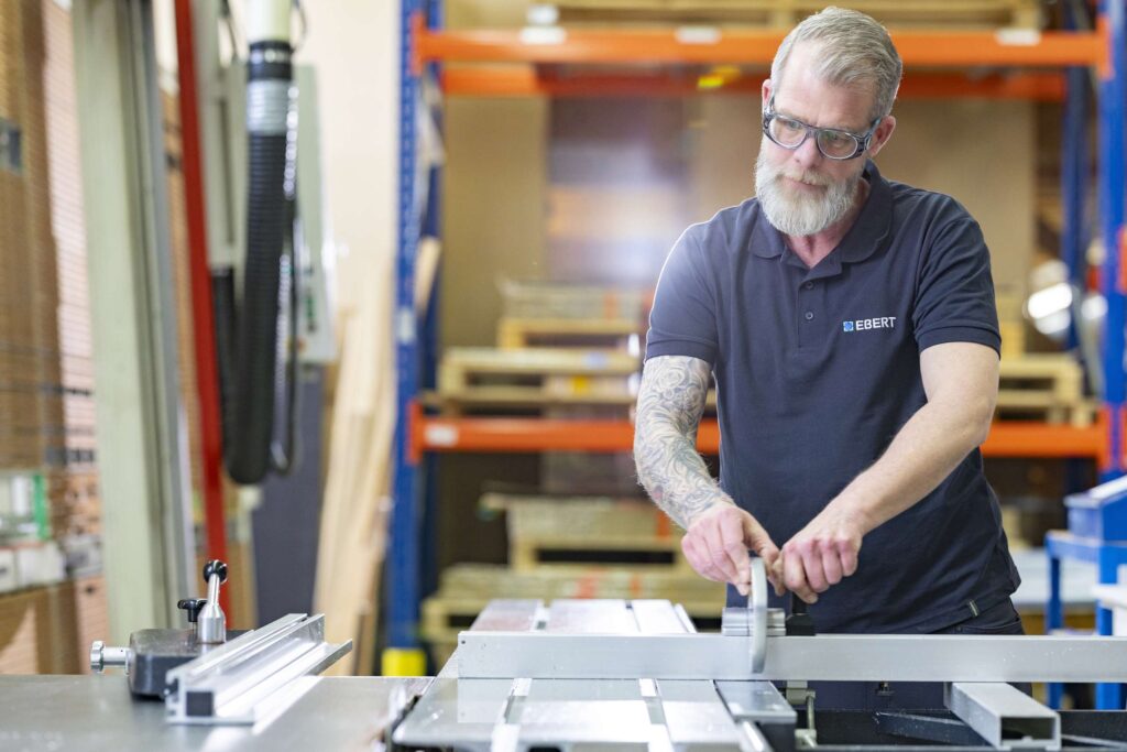 Ein Mitarbeiter von Ebert Kunststoffbearbeitung arbeitet an einer Maschine in der Werkstatt auf der Schwaebischen Alb.
