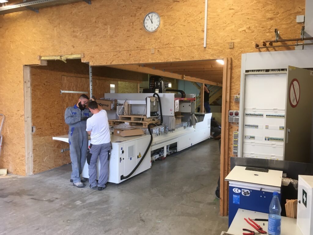 Arbeiter in einer Produktionshalle des Familienunternehmens Ebert Kunststoffbearbeitung mit neuen Maschinen.