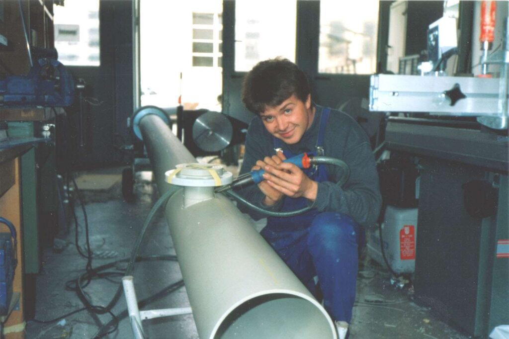 Person bearbeitet Kunststoffrohr in Werkstatt der Ebert Kunststoffbearbeitung.